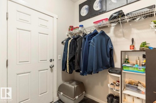 White paneled door with metal hardware, complemented by an overhead wire shelving system - 12737 205 Street Nw, Edmonton, AB - Indoor With Storage