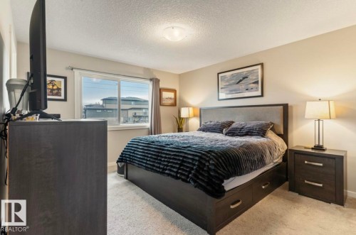 Light-colored carpeting, neutral wall paint, and a built-in bed frame with storage drawers - 12737 205 Street Nw, Edmonton, AB - Indoor Photo Showing Bedroom