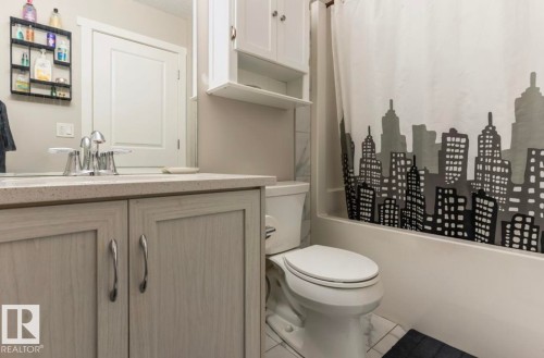 Vanity with a light-toned countertop, a chrome faucet, and light wood-finish cabinetry - 12737 205 Street Nw, Edmonton, AB - Indoor Photo Showing Bathroom