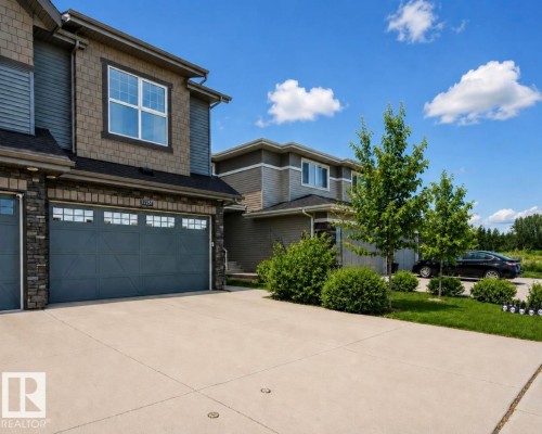Concrete driveway leading to an attached garage with panel detailing - 12737 205 Street Nw, Edmonton, AB - Outdoor