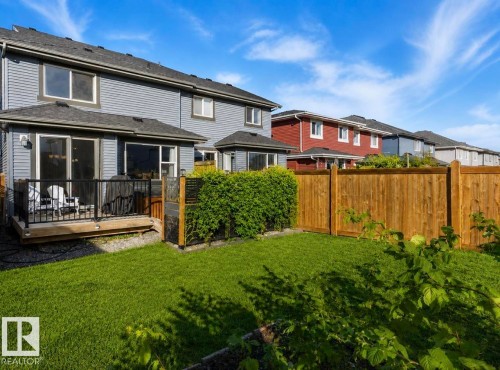 Expansive backyard featuring a manicured lawn, wood privacy fence, and mature hedges - 12737 205 Street Nw, Edmonton, AB - Outdoor With Deck Patio Veranda