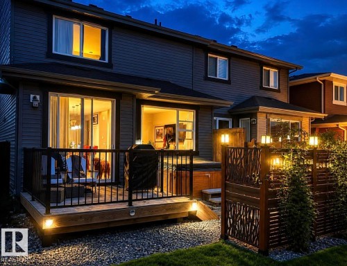 Exterior featuring siding, a wood-finish deck with black railings, and a privacy fence with decorative cutouts - 12737 205 Street Nw, Edmonton, AB - Outdoor With Deck Patio Veranda