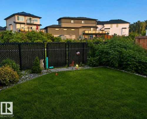 Expansive lawn area with a defined gravel border - 12737 205 Street Nw, Edmonton, AB - Outdoor With Backyard