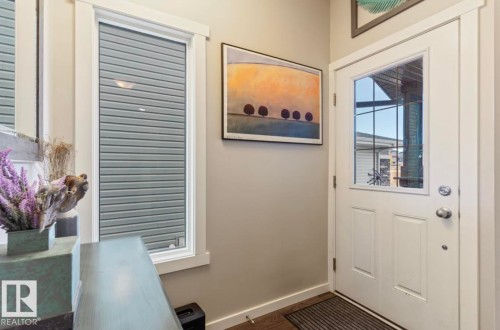 White paneled entry door with glass insert, wood-finish flooring, and neutral wall paint - 12737 205 Street Nw, Edmonton, AB - Indoor Photo Showing Other Room