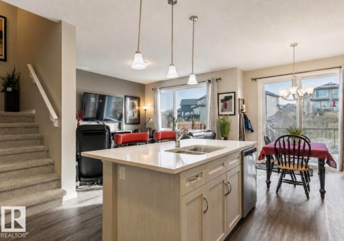Kitchen island with an undermount sink, stainless steel dishwasher, and light-toned cabinetry - 12737 205 Street Nw, Edmonton, AB - Indoor Photo Showing Kitchen With Double Sink