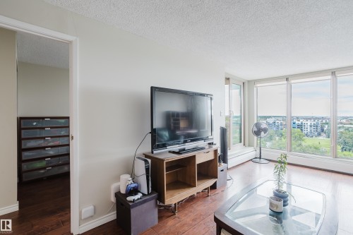 Wood-finish flooring, neutral wall tones, and large windows with roller shades - #1002 10149 Saskatchewan Dr Nw, Edmonton, AB - Indoor