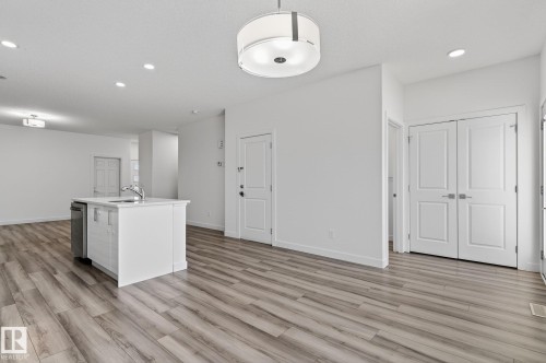 Central kitchen island with an integrated sink and stainless steel dishwasher - 4853 Alwood Point(E) Sw, Edmonton, AB - Indoor