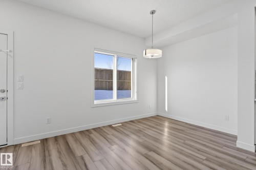 Bright interior with wood-finish flooring and a contemporary drum pendant light fixture - 4853 Alwood Point(E) Sw, Edmonton, AB - Indoor Photo Showing Other Room