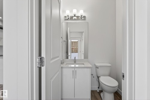 White vanity with a single basin sink, chrome faucet, and integrated countertop - 4853 Alwood Point(E) Sw, Edmonton, AB - Indoor Photo Showing Bathroom