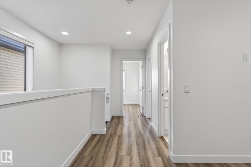 Hallway featuring wood-finish flooring, recessed lighting, white walls, and a window with blinds - 4853 Alwood Point(E) Sw, Edmonton, AB - Indoor Photo Showing Other Room