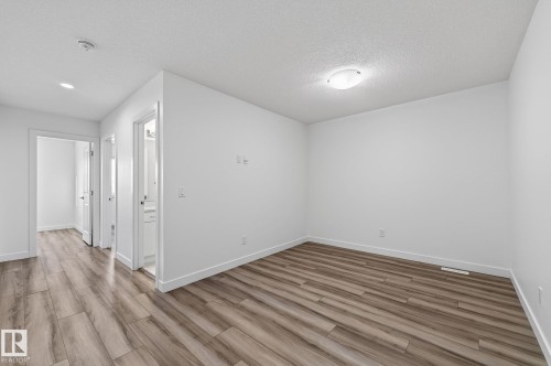 Neutral white walls, wood-finish flooring, recessed ceiling light, and a flush mount ceiling light - 4853 Alwood Point(E) Sw, Edmonton, AB - Indoor Photo Showing Other Room