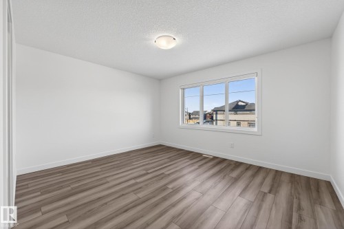 Wood-finish plank flooring throughout - 4853 Alwood Point(E) Sw, Edmonton, AB - Indoor Photo Showing Other Room