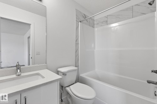 White vanity with integrated sink, chrome faucet, and quartz-finish countertop - 4853 Alwood Point(E) Sw, Edmonton, AB - Indoor Photo Showing Bathroom