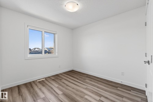 Recessed window with white trim, wood-finish flooring, and white walls - 4853 Alwood Point(E) Sw, Edmonton, AB - Indoor Photo Showing Other Room
