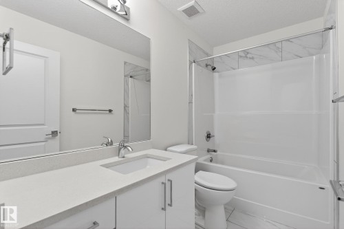Bathroom featuring a vanity with an integrated sink, polished chrome faucet, and under-cabinet storage - 4853 Alwood Point(E) Sw, Edmonton, AB - Indoor Photo Showing Bathroom