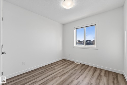 Wood-finish flooring, white painted walls, and a single window with blinds - 4853 Alwood Point(E) Sw, Edmonton, AB - Indoor Photo Showing Other Room