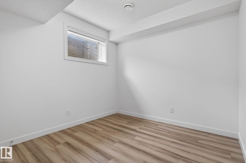 Recessed window, wood-finish flooring, white walls, and a textured ceiling - 4853 Alwood Point(E) Sw, Edmonton, AB - Indoor Photo Showing Other Room