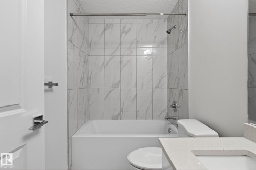 White tub with chrome fixtures and white subway tile surround - 4853 Alwood Point(E) Sw, Edmonton, AB - Indoor Photo Showing Bathroom