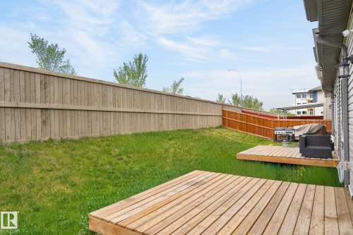 Expansive lawn area with a multi-level wood deck - 4853 Alwood Point(E) Sw, Edmonton, AB - Outdoor With Deck Patio Veranda