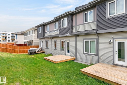 Expansive backyard featuring a manicured lawn, wood fencing, and two wood decks - 4853 Alwood Point(E) Sw, Edmonton, AB - Outdoor With Deck Patio Veranda With Exterior