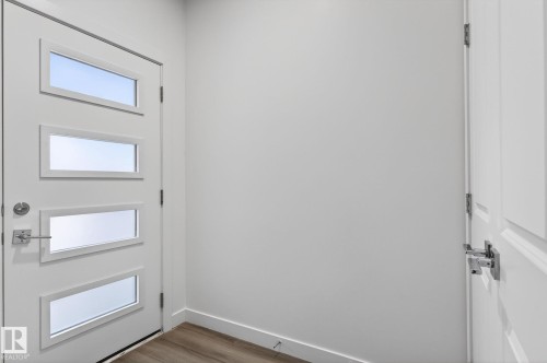 Entry door with four rectangular lites and brushed chrome hardware - 4853 Alwood Point(E) Sw, Edmonton, AB - Indoor Photo Showing Other Room