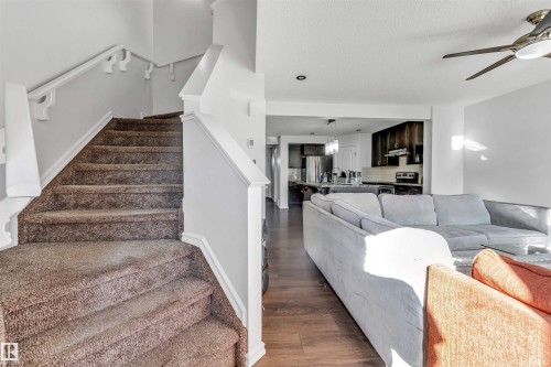 Carpeted staircase with white railings, wood-finish flooring, recessed lighting, and a ceiling fan - 2040 24 Street Nw, Edmonton, AB - Indoor