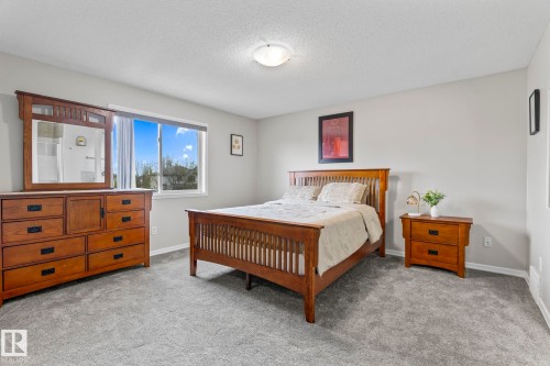 Carpeted room with a ceiling-mounted light fixture, light gray wall paint, and a window with white trim - 3403 23 Nw, Edmonton, AB - Indoor Photo Showing Bedroom