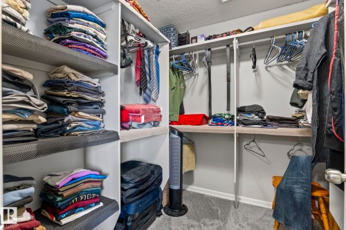 Built-in closet system with multiple shelving units and hanging rods - 3403 23 Nw, Edmonton, AB - Indoor With Storage