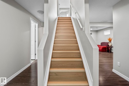 Wood-finish staircase with white risers and handrails - 3403 23 Nw, Edmonton, AB - Indoor Photo Showing Other Room