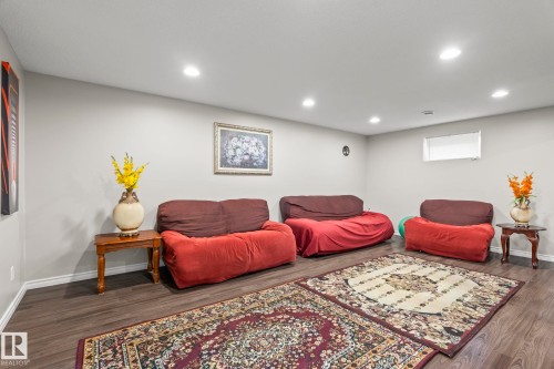 Recessed ceiling lighting illuminates a spacious room featuring wood-finish flooring and light-toned walls - 3403 23 Nw, Edmonton, AB - Indoor Photo Showing Basement