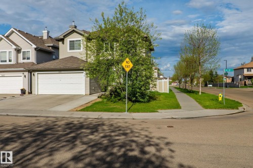 Siding exterior with multiple windows, attached garage, and a concrete driveway - 3403 23 Nw, Edmonton, AB - Outdoor