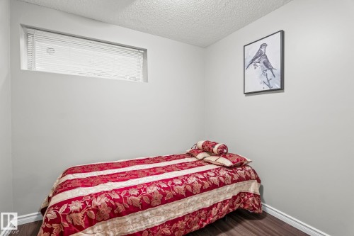 Recessed window with blinds, light gray walls, and wood-finish flooring - 3403 23 Nw, Edmonton, AB - Indoor Photo Showing Bedroom