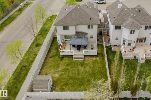Expansive backyard featuring a manicured lawn, a detached storage shed, and a white fence - 3403 23 Nw, Edmonton, AB - Outdoor