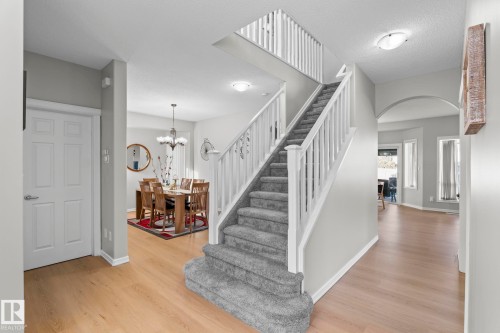 Carpeted staircase with white balusters, wood-finish flooring, and recessed lighting - 3403 23 Nw, Edmonton, AB - Indoor Photo Showing Other Room