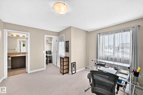 Carpeted room featuring a window with sheer and blackout curtains, a ceiling-mounted light fixture, and neutral wall tones - 466 Chappelle Drive Sw, Edmonton, AB - Indoor