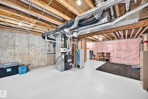 Unfinished basement featuring exposed wood joists, concrete foundation walls, and painted concrete flooring - 466 Chappelle Drive Sw, Edmonton, AB - Indoor Photo Showing Basement