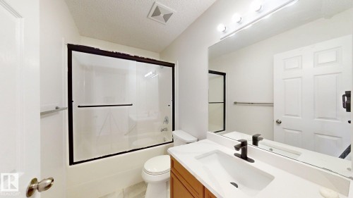 Tub/shower combination with dark-framed glass enclosure - 2426 33A Street Nw, Edmonton, AB - Indoor Photo Showing Bathroom