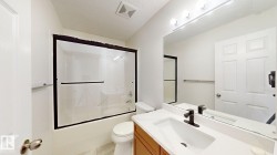 Tub/shower combination with dark-framed glass enclosure - 