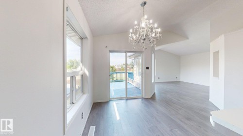Vaulted ceilings, wood-finish flooring, and a crystal chandelier - 2426 33A Street Nw, Edmonton, AB - Indoor Photo Showing Other Room