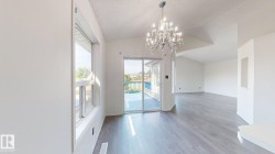 Vaulted ceilings, wood-finish flooring, and a crystal chandelier - 