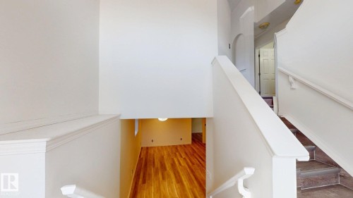 Staircase featuring white painted railings and risers, with wood-finish treads - 2426 33A Street Nw, Edmonton, AB - Indoor Photo Showing Other Room
