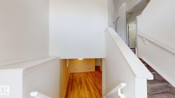 Staircase featuring white painted railings and risers, with wood-finish treads - 