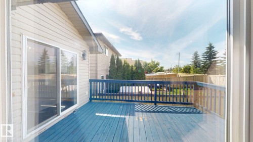 Outdoor deck with blue-painted wood flooring and matching railing - 2426 33A Street Nw, Edmonton, AB - Outdoor With Exterior