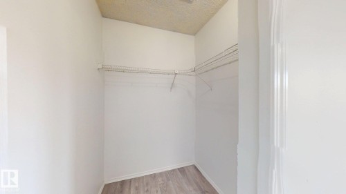 White-painted walls with wood-finish flooring - 2426 33A Street Nw, Edmonton, AB - Indoor With Storage