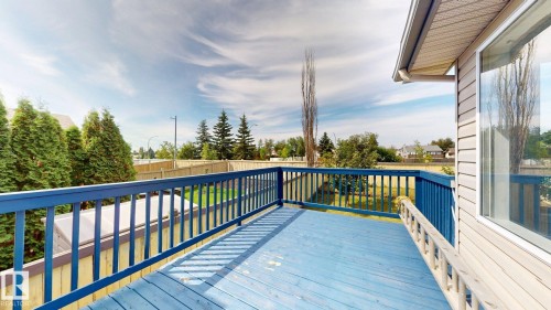 Exterior deck with blue-painted wood-finish flooring and matching railings - 2426 33A Street Nw, Edmonton, AB - Outdoor With Exterior