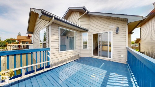 Expansive outdoor deck with blue painted wood flooring and matching railings - 2426 33A Street Nw, Edmonton, AB - Outdoor With Exterior