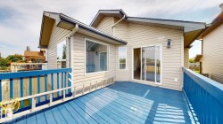 Expansive outdoor deck with blue painted wood flooring and matching railings - 