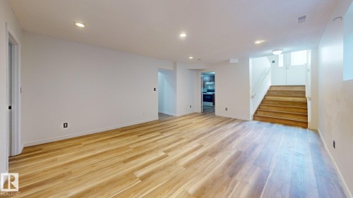 Wood-finish flooring throughout, recessed lighting, and a white interior color palette - 2426 33A Street Nw, Edmonton, AB - Indoor Photo Showing Other Room