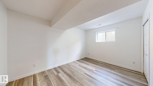 Wood-finish flooring, white walls, and a single window with white trim - 2426 33A Street Nw, Edmonton, AB - Indoor Photo Showing Other Room