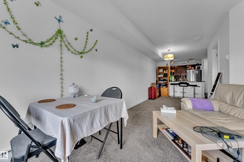 Open-concept living space with light neutral wall tones and carpet flooring - #409 11804 22 Av Sw, Edmonton, AB - Indoor